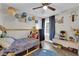 Bright bedroom featuring a wooden twin bed frame, ceiling fan and neutral colored walls at 5228 Harmony Ave, Las Vegas, NV 89107