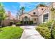 Lovely home exterior featuring manicured lawn, mature landscaping, and charming architectural details at 5381 Waving Sage Dr, Las Vegas, NV 89149