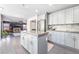 Open kitchen with island and gray cabinets flows into the living room with fireplace and built-in shelving at 5381 Waving Sage Dr, Las Vegas, NV 89149