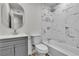 Bathroom featuring tub and shower with marbled tile surround, updated vanity and lighting at 5617 Reiter Ave, Las Vegas, NV 89108
