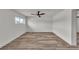 Minimalist bedroom featuring wood-look floors, a ceiling fan, and a bright window at 5617 Reiter Ave, Las Vegas, NV 89108