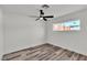Cozy bedroom featuring wood-look floors, a ceiling fan, and a window with outdoor views at 5617 Reiter Ave, Las Vegas, NV 89108