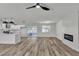 Open living area featuring wood-look floors, white shiplap fireplace, and sliding glass doors to the patio at 5617 Reiter Ave, Las Vegas, NV 89108