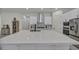 Large kitchen island with white countertops and cabinets and stainless steel appliances at 5851 Slate Rock Ct, Las Vegas, NV 89149