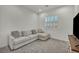 Cozy living room with a comfortable sectional sofa, shuttered window, and gray carpet at 5851 Slate Rock Ct, Las Vegas, NV 89149