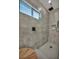 Modern shower with gray tile, unique fixtures, and a window for natural light at 5851 Slate Rock Ct, Las Vegas, NV 89149