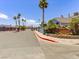 Community entrance with stone sign, palm trees, well-maintained landscaping, and security gates at 5861 Medallion Dr # 202, Las Vegas, NV 89122