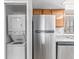 Updated kitchen area with stackable washer/dryer next to stainless steel refrigerator at 5861 Medallion Dr # 202, Las Vegas, NV 89122