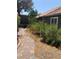 Home's backyard has mature bushes, rock gardens, and a brick sidewalk at 6704 Lost River Ct, Las Vegas, NV 89108