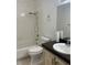 Bathroom with white tiled shower/tub, toilet, vanity with a dark countertop, and decorative fixtures at 6704 Lost River Ct, Las Vegas, NV 89108