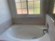 Large soaking tub with tile surround, and window views at 6704 Lost River Ct, Las Vegas, NV 89108