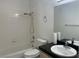 Bathroom featuring a white tiled shower/tub, toilet, vanity with a dark countertop and decorative fixtures at 6704 Lost River Ct, Las Vegas, NV 89108