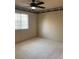 Bedroom with neutral carpet, ceiling fan, and a window allowing natural light at 6704 Lost River Ct, Las Vegas, NV 89108