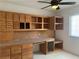 Home office space featuring built-in wooden cabinets, drawers, a desk, a window, and carpet at 6704 Lost River Ct, Las Vegas, NV 89108