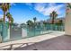 Community pool area surrounded by lush greenery and a secure fence at 7100 Pirates Cove Rd # 2076, Las Vegas, NV 89145