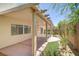Backyard with covered patio, privacy wall, small section of green space and sparse desert landscaping at 7263 Pepperbox Ave, Las Vegas, NV 89179