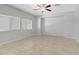 Large, bright and unstaged bedroom with tile floors, large windows and ceiling fan at 7263 Pepperbox Ave, Las Vegas, NV 89179