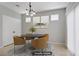 Staged dining area with a modern table and chairs, stylish light fixture, and neutral décor at 7263 Pepperbox Ave, Las Vegas, NV 89179