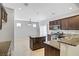 Spacious kitchen features an island, dark wood cabinets, stainless steel appliances, and tiled backsplash at 7263 Pepperbox Ave, Las Vegas, NV 89179