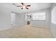 Unstaged living area featuring tile floors, ceiling fan and an open view into the kitchen area at 7263 Pepperbox Ave, Las Vegas, NV 89179