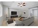 Staged living room with neutral decor, tiled flooring, ceiling fan, and large flat screen television at 7263 Pepperbox Ave, Las Vegas, NV 89179