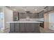 Well-equipped kitchen featuring stainless steel appliances, gray cabinets, a large island, and a quartz countertop at 765 Cloud Creek St, Henderson, NV 89011