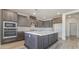 Well-equipped kitchen featuring stainless steel appliances, gray cabinets, a large island, and a quartz countertop at 765 Cloud Creek St, Henderson, NV 89011