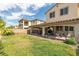 Expansive backyard features a covered patio, lush lawn, mature landscaping, and fencing at 7854 Brianna Cheerful Ave, Las Vegas, NV 89178