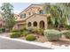 Two-story house featuring an arched entrance, well-maintained lawn, and desert landscaping at 7854 Brianna Cheerful Ave, Las Vegas, NV 89178