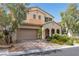 Exterior elevation with brick driveway, arched covered porch, and lush landscaping at 7854 Brianna Cheerful Ave, Las Vegas, NV 89178