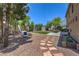 Beautiful backyard featuring artificial turf, lounge area, stone pathway, and trees at 8221 Ebony Peak St, Las Vegas, NV 89143