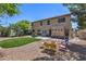 A spacious backyard featuring a covered patio, artificial turf, and mature landscaping at 8221 Ebony Peak St, Las Vegas, NV 89143