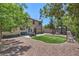 Large backyard featuring artificial turf, mature trees, rock surround and patio at 8221 Ebony Peak St, Las Vegas, NV 89143