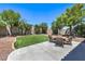 Landscaped backyard with a patio, artificial turf, rock surround and mature trees at 8221 Ebony Peak St, Las Vegas, NV 89143