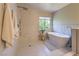 Serene bathroom featuring a freestanding tub, a walk-in shower, and elegant marble-style tiles at 8221 Ebony Peak St, Las Vegas, NV 89143