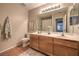 Bathroom with double sink vanity, framed mirror, wood cabinets and tile flooring at 8221 Ebony Peak St, Las Vegas, NV 89143