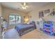 Bedroom with a ceiling fan, window view, and decorated with shelving and sports memorabilia at 8221 Ebony Peak St, Las Vegas, NV 89143