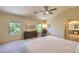 Bright primary bedroom featuring neutral walls, carpet flooring, and large windows overlooking lush trees at 8221 Ebony Peak St, Las Vegas, NV 89143