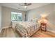 Bedroom featuring light walls, hardwood floors, a ceiling fan, and natural light from the window at 8221 Ebony Peak St, Las Vegas, NV 89143