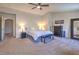 Spacious primary bedroom featuring neutral walls, carpet flooring, ceiling fan, and ensuite bathroom at 8221 Ebony Peak St, Las Vegas, NV 89143