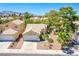 Aerial view of single-story house with desert landscaping, two car garage, and desert mountain views at 8324 Tide Pool Dr, Las Vegas, NV 89128