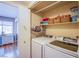 Well-organized laundry room area with modern washer/dryer, storage shelves, and a folding door at 8324 Tide Pool Dr, Las Vegas, NV 89128