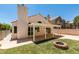 A backyard with a covered patio, small grassy area, and a charming brick fire pit at 87 Ginger Lily Ter, Henderson, NV 89074