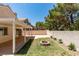 View of the backyard with a covered patio, brick fire pit, and mature landscaping at 87 Ginger Lily Ter, Henderson, NV 89074