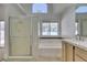 Bathroom featuring a glass-enclosed shower, soaking tub, and double sinks at 87 Ginger Lily Ter, Henderson, NV 89074