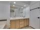 Bathroom with double sinks, wood cabinets, and a large mirror at 87 Ginger Lily Ter, Henderson, NV 89074