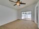 Bright bedroom featuring a ceiling fan, neutral carpet, and sliding glass door to outdoor space at 87 Ginger Lily Ter, Henderson, NV 89074