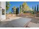 Spacious backyard featuring a concrete patio, mature trees, and a brick perimeter on a sunny day at 8809 Beach Front Dr, Las Vegas, NV 89117