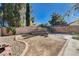 Landscaped backyard with trees, decorative brick, concrete walkways, and block wall fencing at 8809 Beach Front Dr, Las Vegas, NV 89117