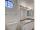 Bathroom featuring a vanity with granite countertop, modern fixtures and a unique geometric window at 8809 Beach Front Dr, Las Vegas, NV 89117